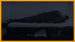 teen boy sleeping in a jail cell