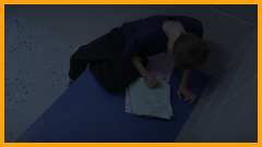 young teen boy doing homework in a cell